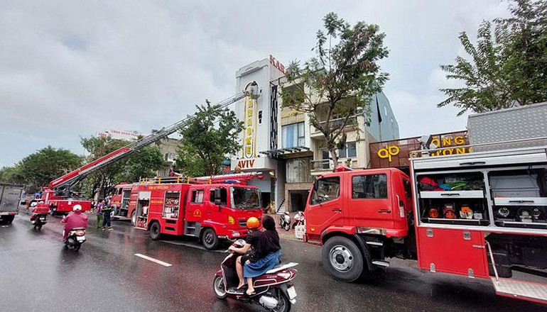 Lực lượng chức năng đục tường, tiếp cận đám cháy bằng xe thang. (Ảnh: V.Đ)