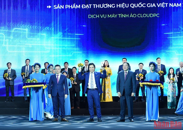 Đồng chí Nguyễn Văn Hùng, Ủy viên Trung ương Đảng, Bộ trưởng Văn hóa Thể thao và Du lịch và đồng chí Lê Quốc Minh, Ủy viên Trung ương Đảng, Tổng Biên tập Báo Nhân Dân, Phó Trưởng Ban Tuyên giáo Trung ương, Chủ tịch Hội Nhà báo Việt Nam trao hoa, biểu trưng cho các Doanh nghiệp có sản phẩm đạt Thương hiệu quốc gia Việt Nam.