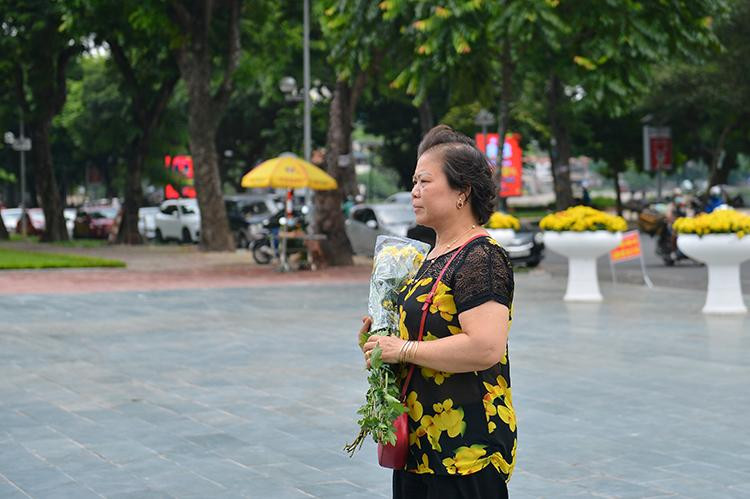 Bà Nguyễn Minh Nguyệt mang 3 bó hoa tươi tới tượng đài để tri ân 3 chiến sĩ cảnh sát PCCC.