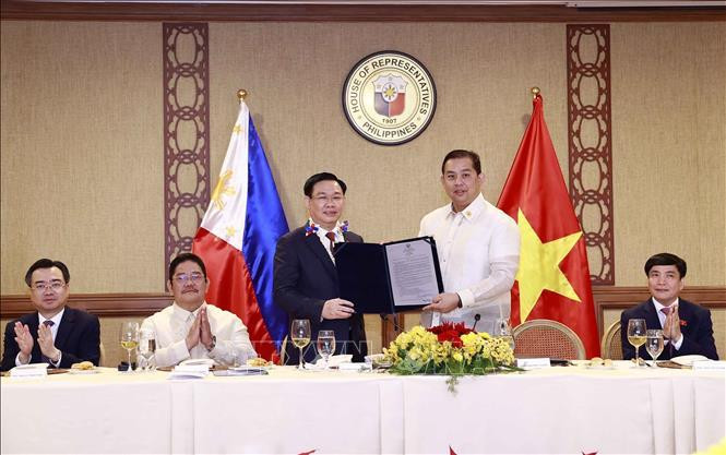 Chủ tịch Hạ viện Martin Romualdez trao Nghị quyết số 571 về tăng cường hợp tác giữa Philippines và Việt Nam với việc thành lập Nhóm Nghị sĩ hữu nghị Philippines - Việt Nam cho Chủ tịch Quốc hội Vương Đình Huệ. (Ảnh: Doãn Tấn - TTXVN)