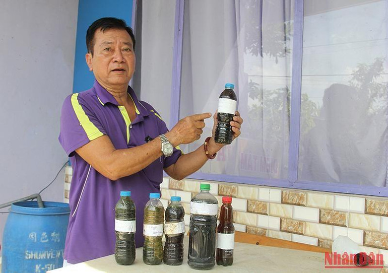 Ông Nguyễn Văn Lợi, chủ nhà máy nước ấp Phú Hưng, xã Hòa Phú, huyện Long Hồ, tỉnh Vĩnh Long lấy mẫu nước sông bị nước rỉ rác gây ô nhiễm.