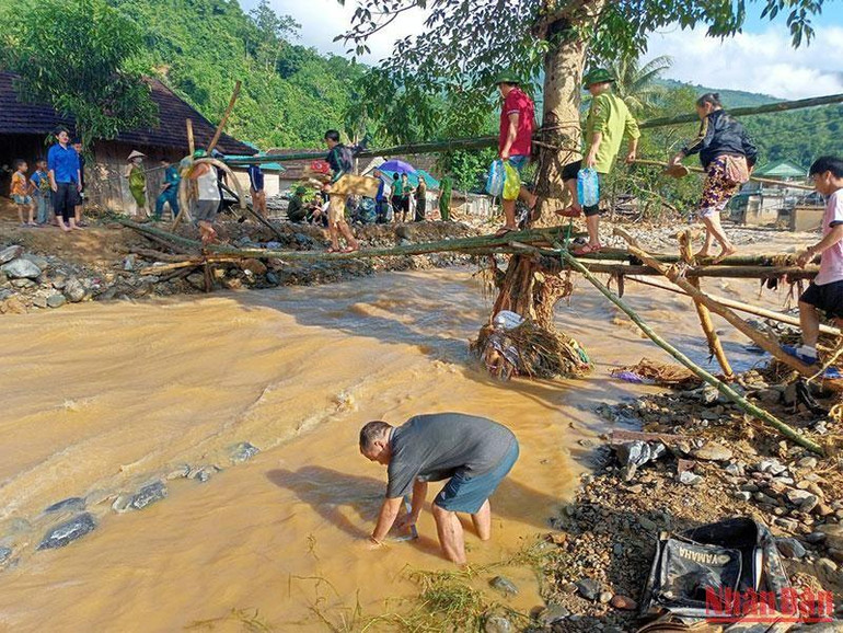 Nước suối Huồi Giảng dâng cao, bộ đội và dân quân làm cầu tạm qua để ứng cứu cho các hộ dân bản Hòa Sơn bên kia suối.