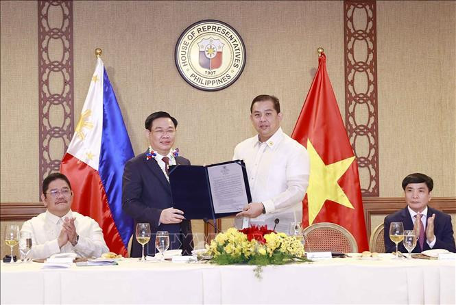 Chủ tịch Hạ viện Martin Romualdez trao Nghị quyết số 571 về tăng cường hợp tác giữa Philippines và Việt Nam với việc thành lập Nhóm Nghị sĩ hữu nghị Philippines - Việt Nam cho Chủ tịch Quốc hội Vương Đình Huệ. (Ảnh: Doãn Tấn - TTXVN)