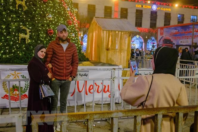 Du khách thích thú thưởng thức đồ trang trí Giáng sinh ở Bethlehem. (Ảnh: Quang Minh/TTXVN) Du khách thích thú thưởng thức đồ trang trí Giáng sinh ở Bethlehem. (Ảnh: Quang Minh/TTXVN)