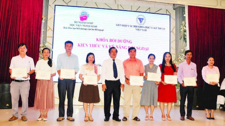 Các học viên nhận chứng chỉ khóa bồi dưỡng kiến thức và kỹ năng đối ngoại nhân dân. (Ảnh THÁI KHOA)