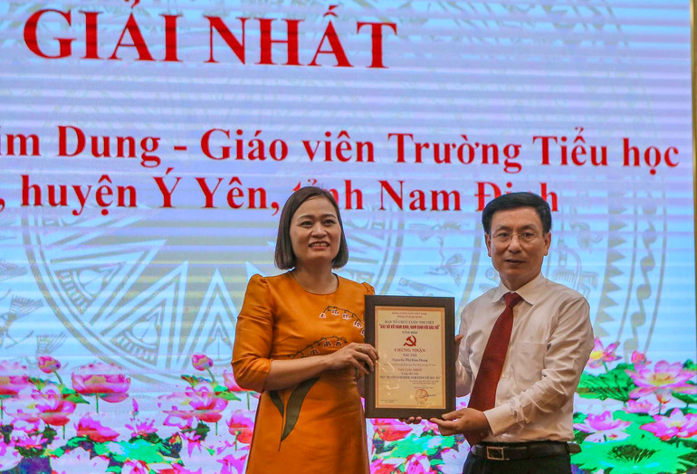 Đồng chí Phạm Đình Nghị, Chủ tịch Ủy ban nhân dân tỉnh Nam Định trao giải Nhất cho bà Nguyễn Thị Kim Dung, giáo viên Trường Tiểu học Yên Trị, huyện Ý Yên.