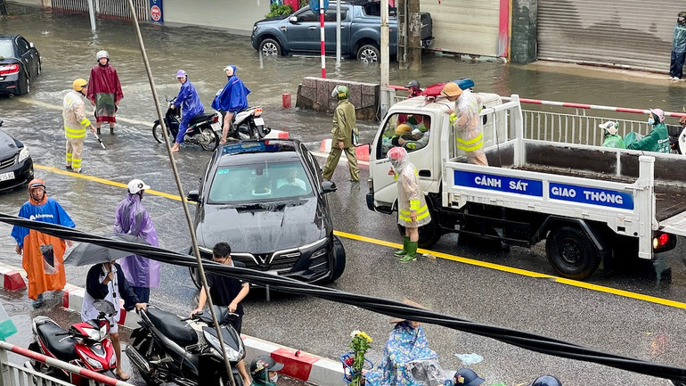Các cán bộ, chiến sĩ cảnh sát giao thông-trật tự đội mưa điều tiết, hướng dẫn các phương tiện di chuyển qua cầu Đò Quan.
