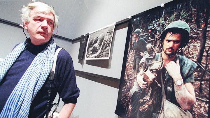 Nhiếp ảnh gia Tim Page bên một tác phẩm của mình. Ảnh: GETTY