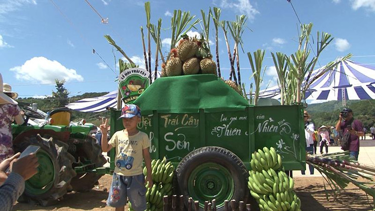 Người dân thích thú chụp ảnh cùng cây trái địa phương.