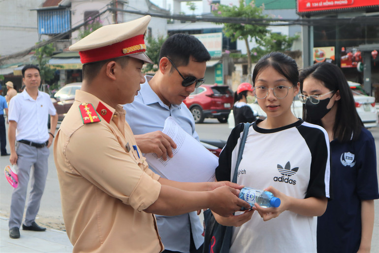 Các chiến sĩ Đội Cảnh sát Giao thông, Công an thành phố Vinh tặng nước uống, động viên các sĩ tử hoàn thành tốt bài thi.