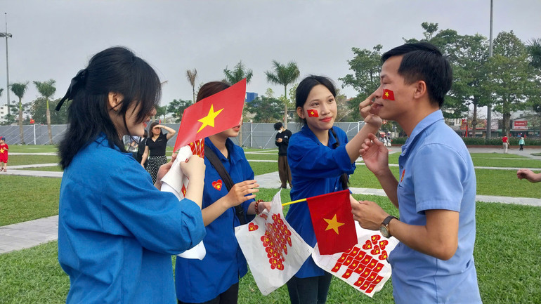 Người dân thích thú khi được dán sticker hình lá cờ Tổ quốc khi đến Quảng trường Hồ Chí Minh để cùng chung "nhịp đập" tự hào.