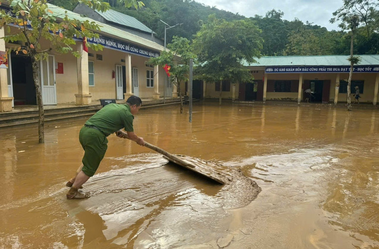 Lực lượng Công an giúp Trường phổ thông dân tộc bán trú tiểu học Lượng Minh ở bản Minh Tiến dọn dẹp bùn đất trong sáng 1/10.