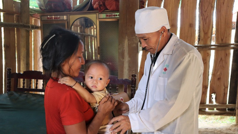 Cán bộ quân y Bộ đội Biên phòng tỉnh Nghệ An thăm khám sức khỏe cho bà con người Đan Lai ở bản Cò Phạt.