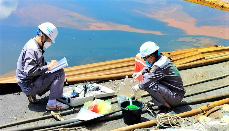 Cơ quan chức năng lấy mẫu nước tại bể lắng của Công ty trách nhiệm hữu hạn Thiếc Hà An để tiến hành quan trắc.