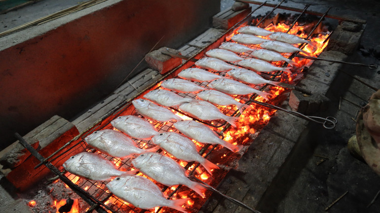 Trong thời tiết mưa lạnh của mùa đông, bếp than rực hồng, mùi cá nướng tỏa thơm phức gây ấn tượng mạnh với những người ghé thăm làng biển.