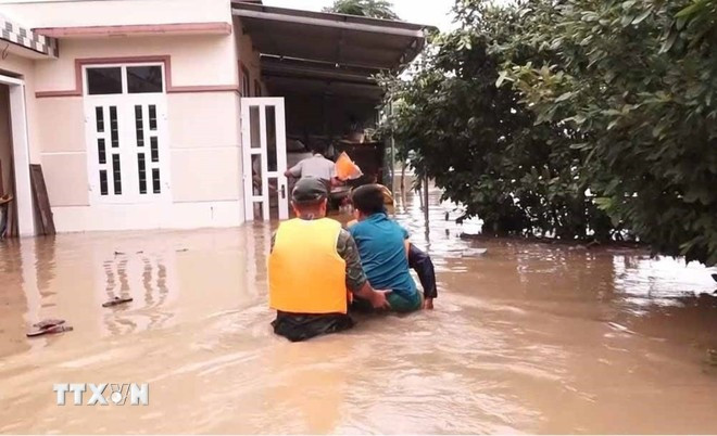 Lực lượng chức năng tiếp cận, hỗ trợ di dời người dân vùng ngập sâu ở phường Phổ Minh, thị xã Đức Phổ, Quảng Ngãi, đến nơi an toàn. (Ảnh: TTXVN)