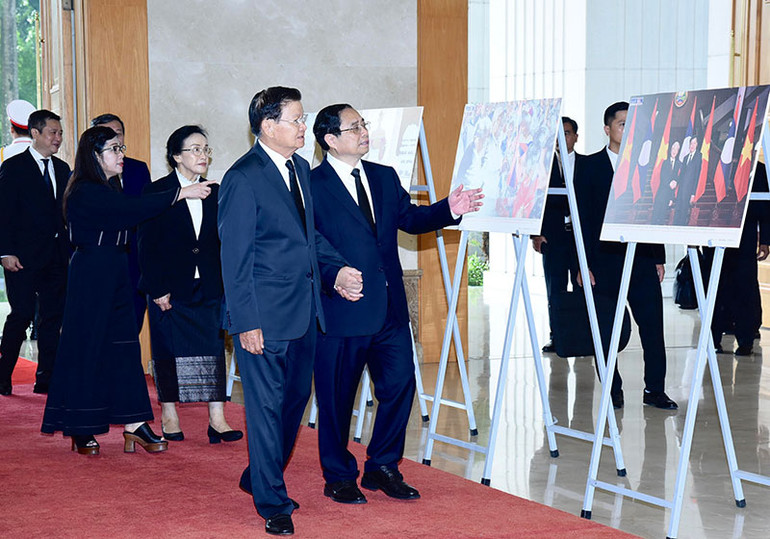 Thủ tướng Phạm Minh Chính giới thiệu với Tổng Bí thư, Chủ tịch nước Lào Thongloun Sisoulith một số hình ảnh về hoạt động đối ngoại của Tổng Bí thư Nguyễn Phú Trọng.