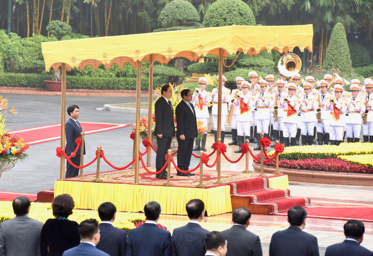 Thủ tướng Phạm Minh Chính và Thủ tướng Chính phủ nước Cộng hòa Dân chủ Nhân dân Lào Sonexay Siphandone thực hiện nghi lễ chào cờ hai nước.