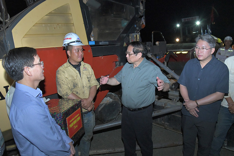 Thủ tướng Phạm Minh Chính thăm hỏi một công nhân trên công trường.