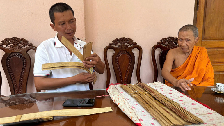 Anh Ry Thy miêu tả cách xâu chuỗi các lá buông đã khắc chữ thành quyển sách kinh.