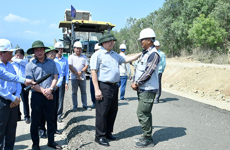 Thủ tướng Phạm Minh Chính hỏi thăm một cán bộ đang thi công nền đường Dự án đường bộ cao tốc Vân Phong-Nha Trang. Thủ tướng Phạm Minh Chính hỏi thăm một cán bộ đang thi công nền đường Dự án đường bộ cao tốc Vân Phong-Nha Trang.