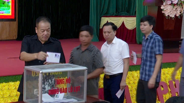 Các đồng chí lãnh đạo, cán bộ huyện biên giới Mường Nhé (tỉnh Điện Biên) ủng hộ đồng bào vùng bão, lũ.