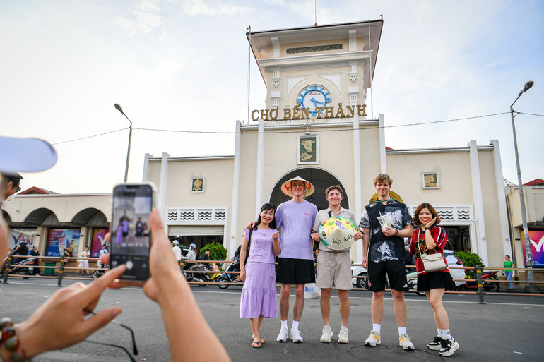 Du khách check-in trước chợ Bến Thành. (Ảnh: THÀNH ĐẠT)
