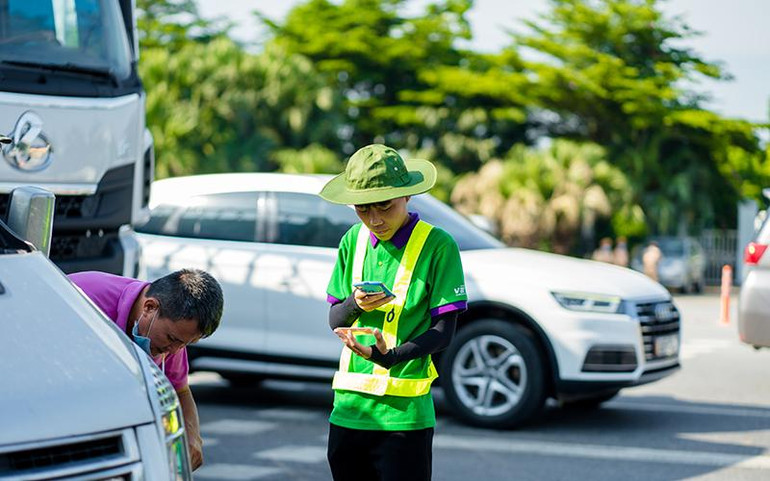 Nhân viên cung cấp dịch vụ ETC hướng dẫn, hỗ trợ khách hàng dán thẻ, nạp tiền vào tài khoản.