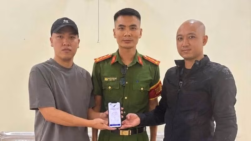 Anh Hoàng Quốc Cường (bên trái) trả lại 5 tỷ đồng chuyển khoản nhầm cho anh Quân trước sự chứng kiến của đại diện Công an xã Hoàn Lão. (Ảnh: Công an xã Hoàn Lão)