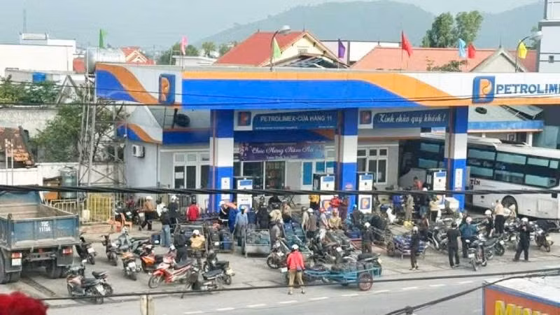 Cảnh người dân kéo xe ba gác với nhiều can nhựa đến mua xăng dầu tại cửa hàng ở khu vực Roòn, xã Phú Trạch sáng nay.