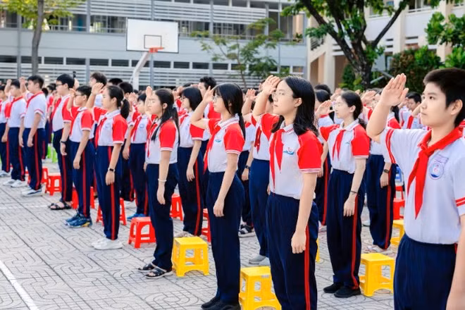 Học sinh Trường trung học cơ sở Nguyễn An Ninh, phường Tam Thắng, Thành phố Hồ Chí Minh chào cờ. 