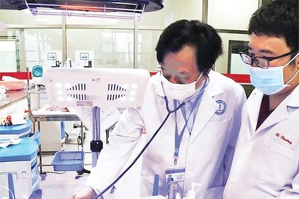 Giáo sư, Tiến sĩ, Thầy thuốc Nhân dân, Anh hùng Lao động thời kỳ đổi mới Tạ Văn Trầm (bên trái) khám bệnh cho bệnh nhi.