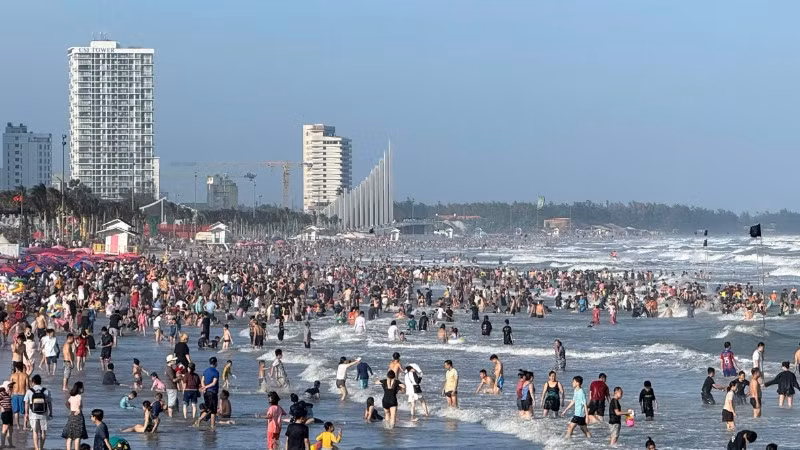 Du khách tắm biển bãi Sau, Thành phố Hồ Chí Minh chiều 18/2. 