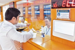 Giải quyết thủ tục hành chính cho người dân tại Bộ phận một cửa UBND quận Long Biên. Ảnh: MINH HÀ