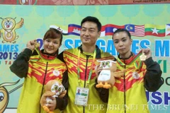 Hai VĐV Wushu Brunei Lee Ying Shi và Faustina Woo Wai Sii cùng HLV sau khi giành HCV.