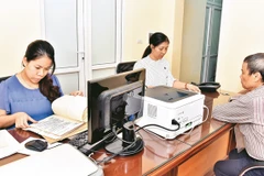 Cán bộ bộ phận một cửa quận ủy Thanh Xuân giải quyết thủ tục hành chính về công tác Đảng cho đảng viên.