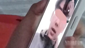 Ảnh cắt từ clip em T.D.H gọi điện thoại thông báo cho gia đình.