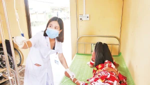 Bác sĩ Trạm y tế xã Đường Hoa điều trị, chăm sóc sức khỏe cho người dân.