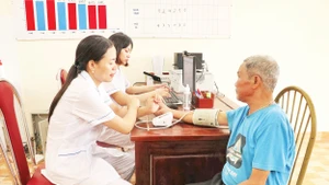 Các y bác sĩ tại Trạm y tế xã Gia Thủy cũ (xã Nho Quan mới), tỉnh Ninh Bình kiểm tra sức khỏe cho người bệnh. Ảnh: TTXVN