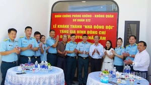 Các đại biểu dự buổi khánh thành và bàn giao “Nhà đồng đội” chụp ảnh lưu niệm với gia đình Đại úy Huỳnh Khắc Tâm. (Ảnh: VĂN TÂM)