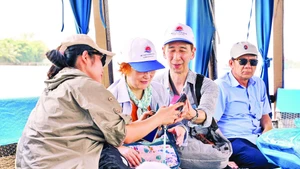 Bạn trẻ hướng dẫn vợ chồng du khách Nhật tham quan miền Tây. Ảnh: Nguyệt Anh
