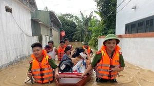 Công an tỉnh Nghệ An hỗ trợ di dời người dân vùng bị ngập lũ do bão số 3 đến nơi an toàn. (Ảnh PHẠM THỦY)