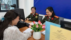 Cán bộ Công an thành phố Hà Nội hướng dẫn người dân kê khai làm thủ tục cấp hộ chiếu.