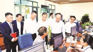 Lãnh đạo thành phố Hà Nội trao đổi với người dân đến làm thủ tục hành chính tại điểm Phục vụ hành chính công xã Phú Xuyên. (Ảnh LÊ HẢI)