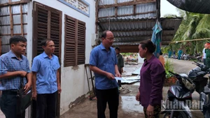 Bí thư Tỉnh ủy Cà Mau Nguyễn Hồ Hải (cầm phong bì) trao hỗ trợ cho hộ dân ấp Nhà Lầu 2 có nhà bị tốc mái.