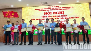 Chủ tịch Ủy ban nhân dân tỉnh Cà Mau Phạm Thành Ngại (giữa) tặng Bằng khen cho các tập thể đóng góp tích cực thực hiện Chương trình xóa nhà tạm, nhà dột nát.