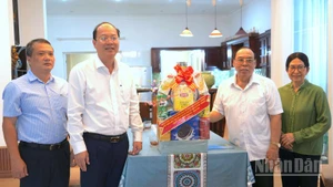 Bí thư Tỉnh ủy Nguyễn Hồ Hải (thứ hai, từ trái qua) trao tặng quà cho gia đình đồng chí Phạm Thanh Trị.