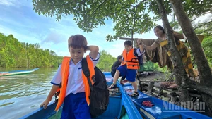 Học sinh xã Đất Mũi (tỉnh Cà Mau) dậy sớm đến trường vào ngày khai giảng năm học mới.