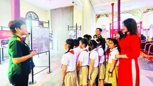 Thế hệ trẻ phường Hoàn Kiếm tìm hiểu về lịch sử hào hùng của lực lượng vũ trang Thủ đô tại triển lãm.