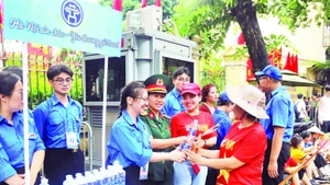 Đoàn viên thanh niên phường Hoàn Kiếm nhiệt tình giúp đỡ mọi người đến xem luyện tập diễu binh, diễu hành.